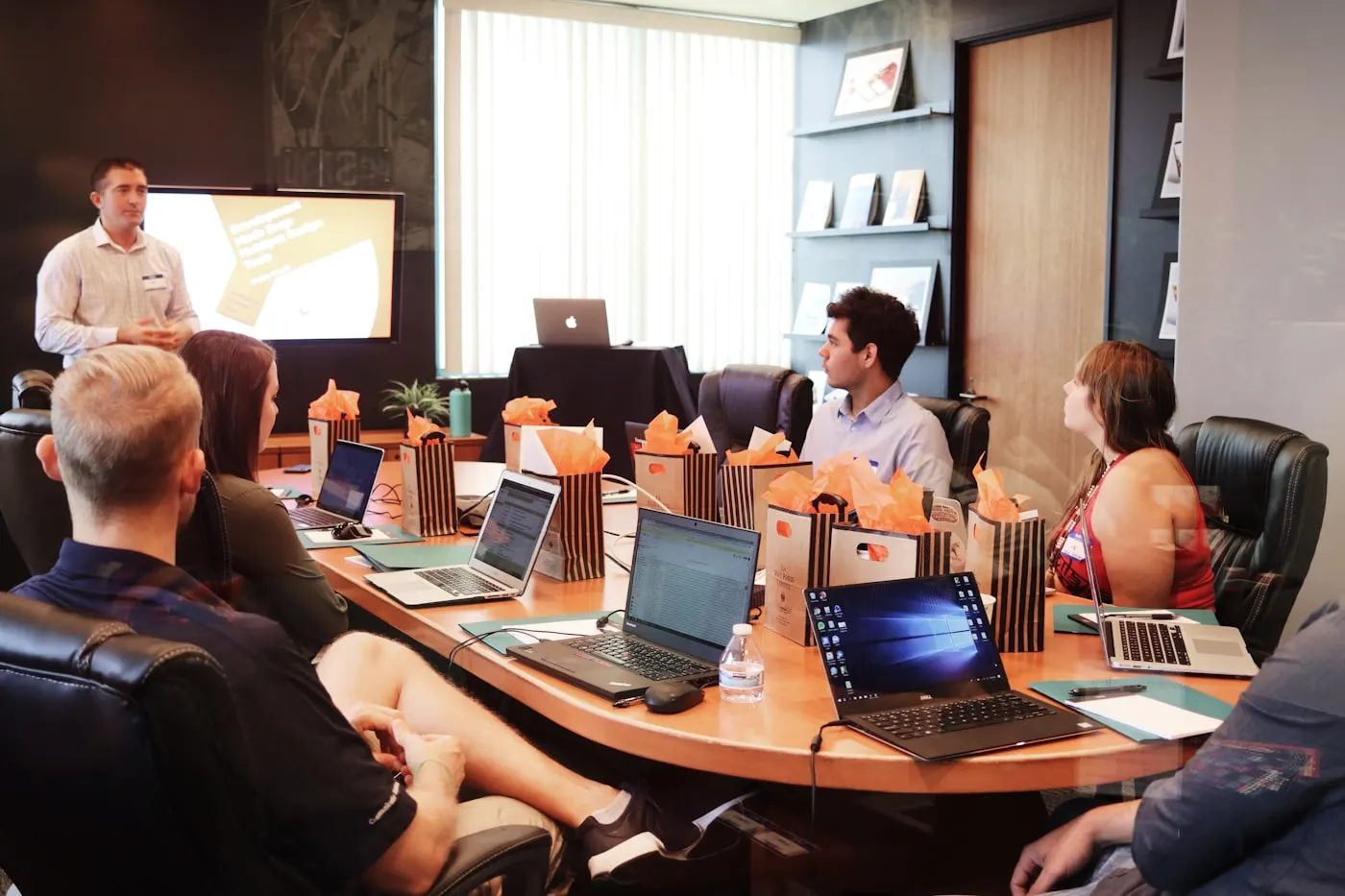 Colleagues discussing work around a meeting table